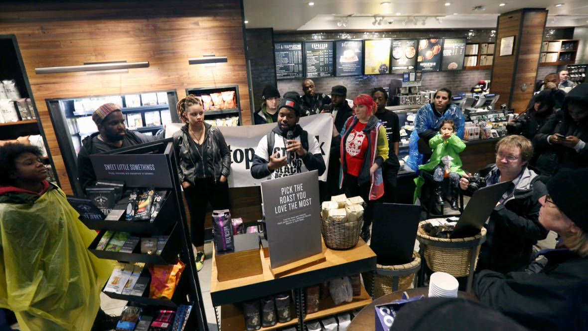 Demonstrators occupy the Starbucks that has become the centre of protests in Philadelphia. The company plans to close more than 8,000 U.S. stores in May for racial bias training for its staff. (Jacqueline Larma/Associated Press)
