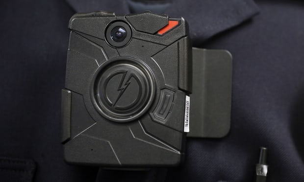 A police officer demonstrates the use of a body camera. Photograph: Damian Dovarganes/AP