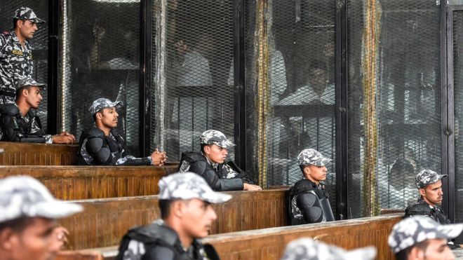 AFP / Defendants look out into the court in Cairo
