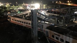 The scene of the crash pictured in the dark with responders at the sceneImage copyrightTAIWAN RAILWAY ADMINISTRATION / HANDOUT / Rescue operations are continuing into the night