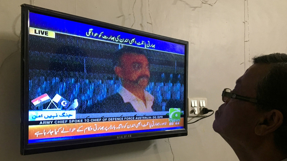 A man looks at television screen, airing live transmission of released Indian pilot Wing Commander Abhi Nandan, at Wagah border, in Karachi © REUTERS/Akhtar Soomro