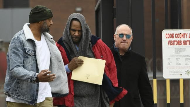 Singer R. Kelly center, walks with his lawyer, Steve Greenberg (right), and an unidentified man left, who gave him a ride after being released from Cook County Jail today. Picture: APSource:AP