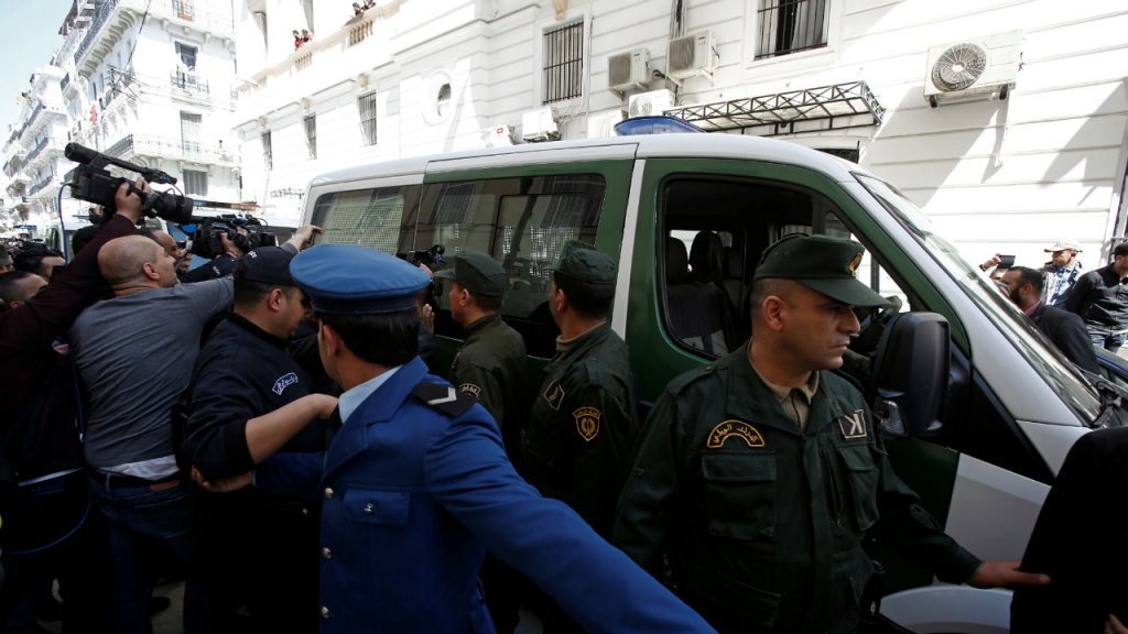 Ramzi Boudina, Reuters | Media and police surround a convoy of police vehicles as businessmen suspected of corruption are driven to court in Algiers on April 23, 2019.