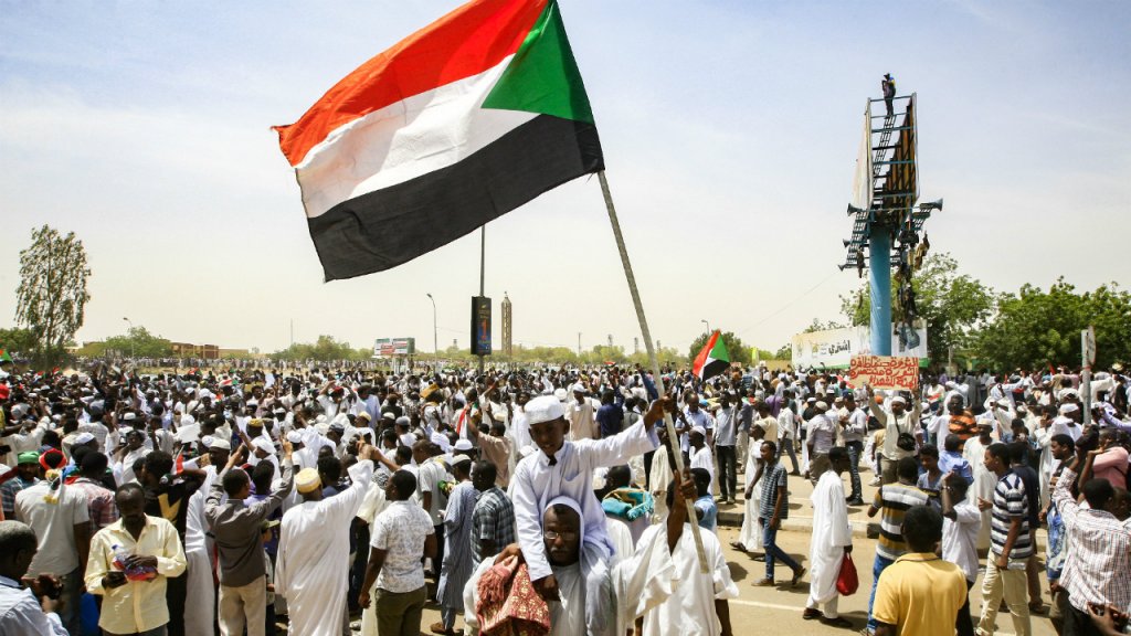 Ebrahim Hamid, AFP | A Sudanese boy waves a national flag during a rally demanding a civilian body to lead the transition to democracy, outside the army headquarters in the Sudanese capital Khartoum on April 11, 2019.