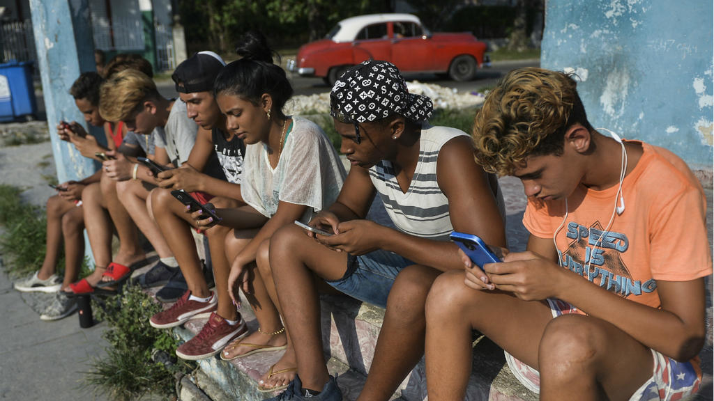 Yamil Lage, AFP | Young Cubans connect to the internet from their mobile phone in Havana, on June 6, 2019.
