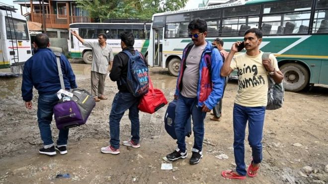 Tourists wait for buses to leave Kashmir on August 3 / GETTY IMAGES Image caption Tourists wait for buses to leave Kashmir