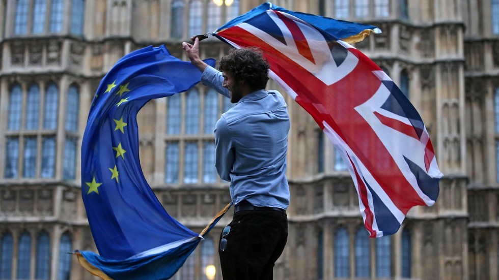 A man waves both a British flag and a European Union flag together outside The Houses of Parliament © AFP / Justin Tallis 4