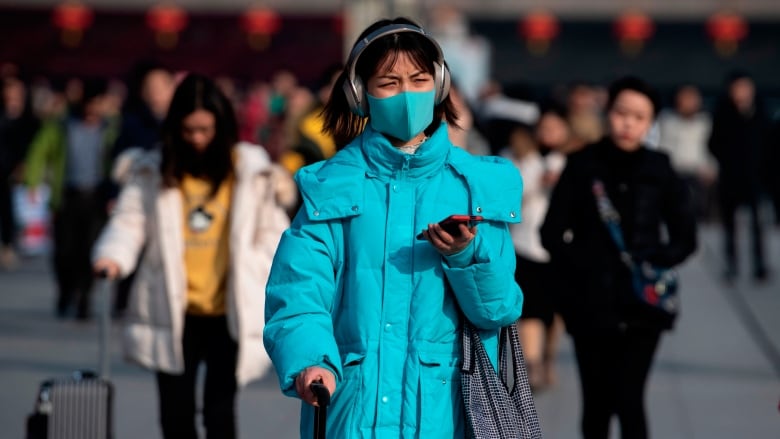 Passengers arrive Monday at the train station in Hanzhong, a mountainous region of Shaanxi province, ahead of the Lunar New Year. A mysterious SARS-like virus has killed a third person and spread around China, including to Beijing. (Noel Celis/