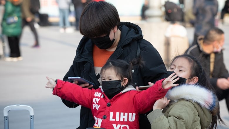 Travellers try to protect themselves from the coronavirus at the Beijing railway station, as they leave for China’s Lunar New Year holiday (Sasa Petricic/CBC News)