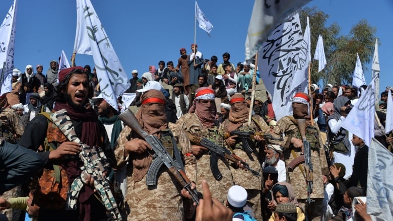 Afghan Taliban militants and villagers are shown at a gathering Monday as they celebrated the deal signed with the U.S., in the province of Laghman. According to Afghan officials, the Taliban have resumed attacks after a 'reduction in violence' 