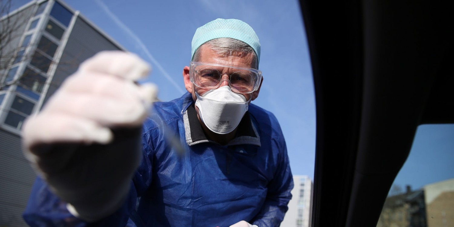 German doctor Michael Grosse takes a sample at a drive-thru testing point in Halle, Germany. Photo by Ronny Hartmann / AFP via Getty