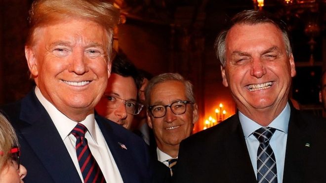 Fabio Wajngarten (2nd left partially obscured) was pictured standing behind President Trump in the meeting with President Jair Bolsonaro