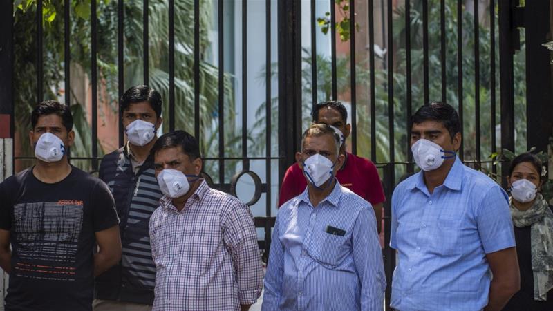 People wear protective masks during a one-day nationwide curfew imposed as a preventive measure against COVID-19 on Sunday [Yawar Nazir/Getty Images]