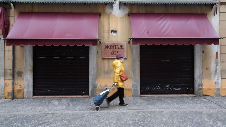 A woman walks in Codogno, Italy, Thursday, March 12, 2020. The northern Italian town was the epicentre for Italy's coronavirus explosion. (Antonio Calanni/The Associated Press)