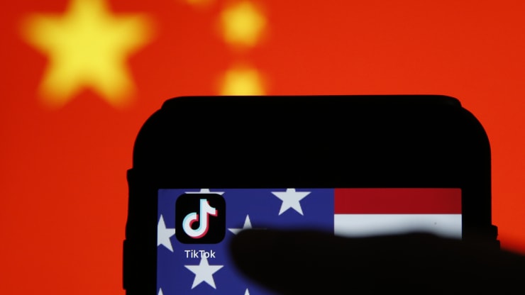 The TikTok app icon sits displayed on a smartphone in front the national flags of China and the U.S. in this arranged photograph in London, U.K., on Monday, Aug. 3, 2020. Hollie Adams | Bloomberg | Getty Images