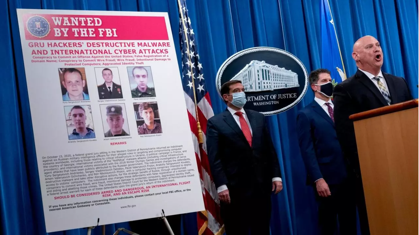 A poster showing six wanted Russian military intelligence officers is displayed as FBI agents and Assistant Attorney General John Demers address a news conference on October 19, 2020 in Washington, D.C., USA. A poster showing six wanted Russian military i