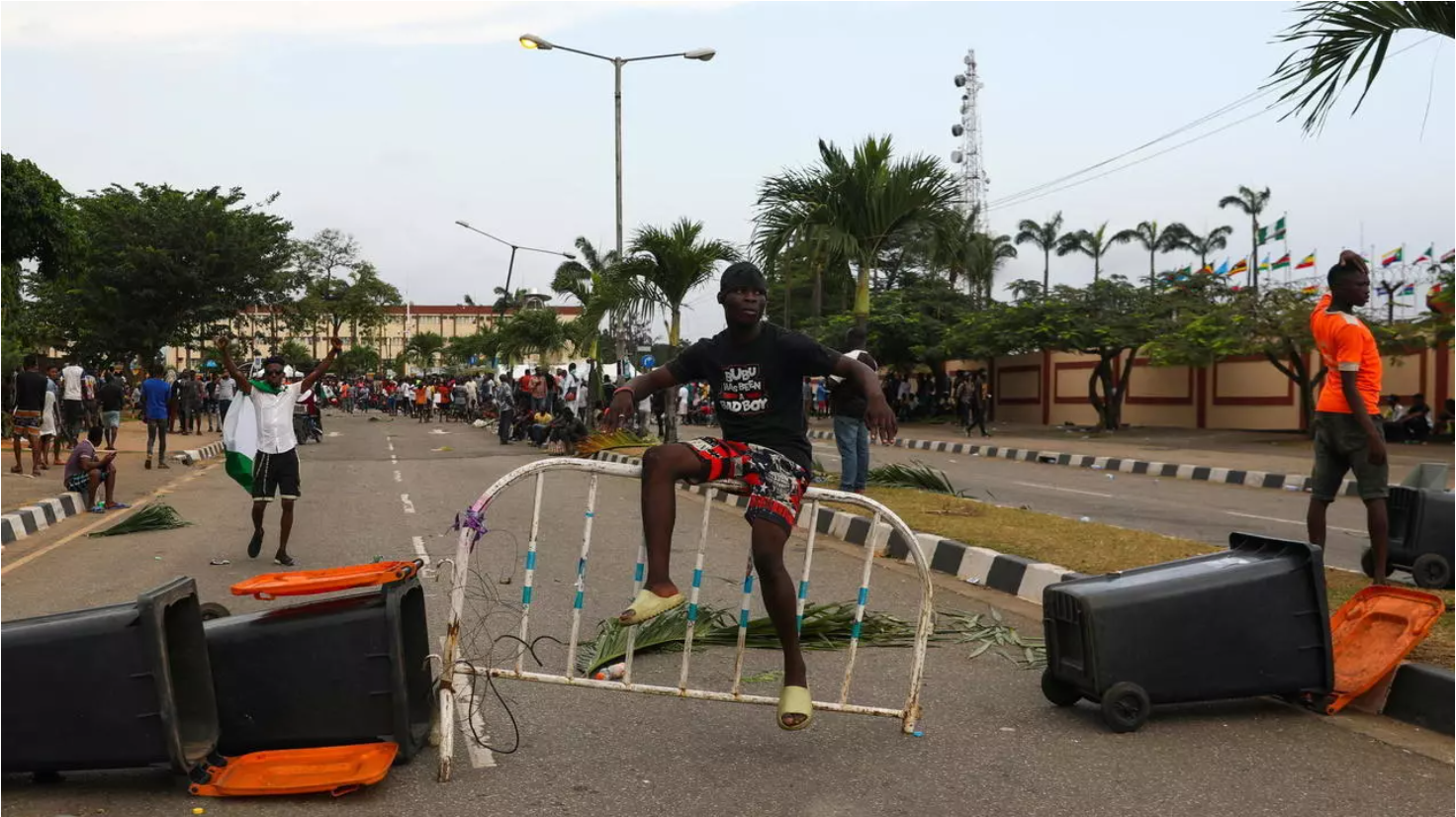 A demonstrator sits on a barricade blocking a road near the Lagos State House, despite a round-the-clock curfew imposed by the authorities on the Nigerian state of Lagos in response to protests against alleged police brutality, Nigeria October 20, 2020.