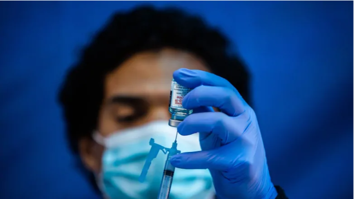 Medical worker Robert Gilbertson loads a syringe with the Moderna Covid-19 vaccine to be administered by nurses at a vaccination site in Los Angeles on Tuesday. During a recent study, researchers determined that half the amount of Moderna's COVID-19 