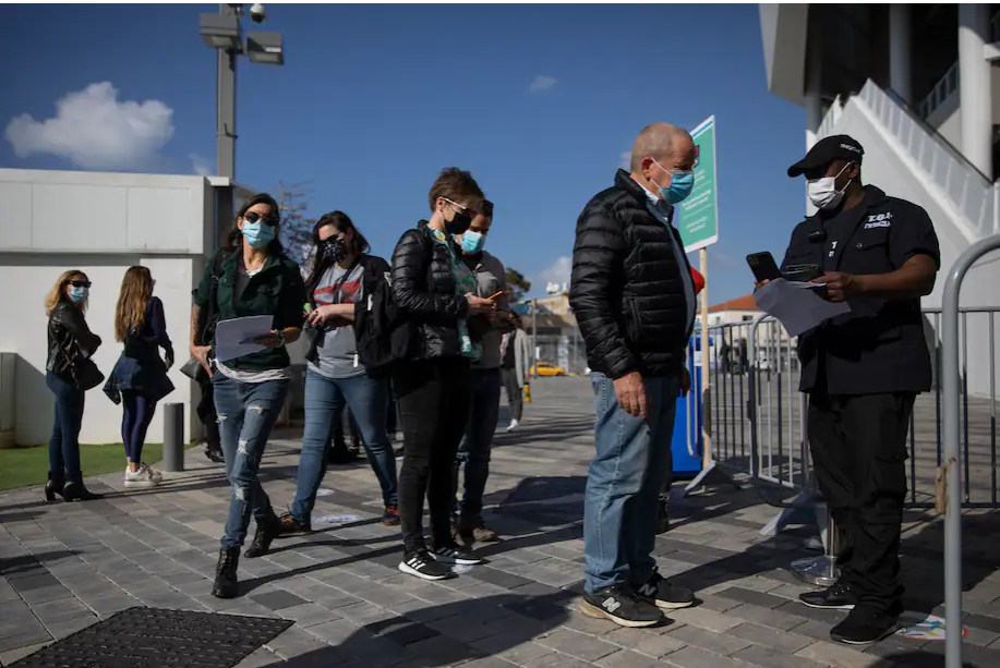 Concertgoers show their "green passport" proof of a coronavirus vaccination or full recovery from the virus to enter a Tel Aviv soccer stadium for a musical performance March 5. (Oded Balilty/AP)