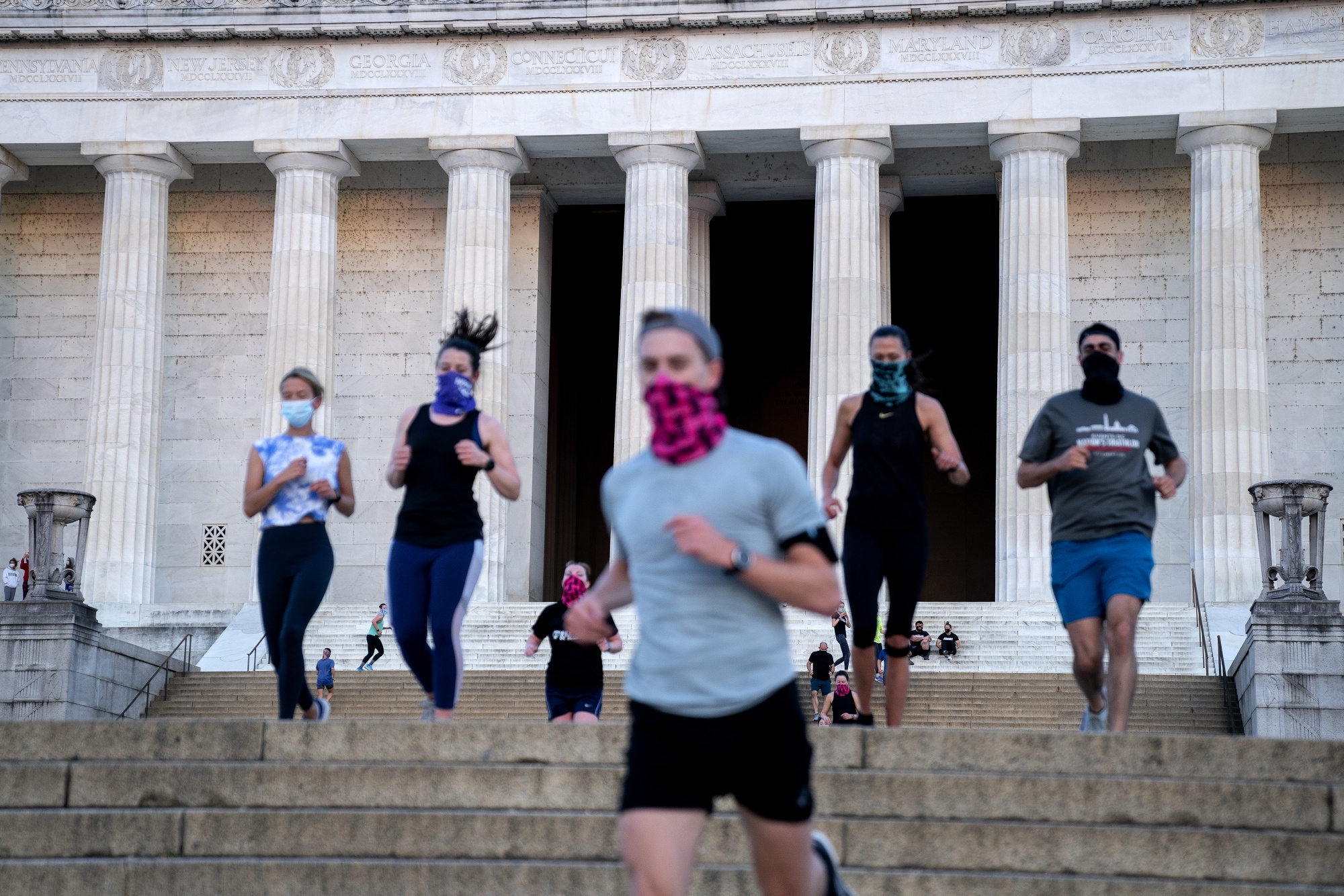 People wear protective masks while exercising at the Lincoln Memorial in Washington on April 21. Under the newly-announced CDC guidelines, the masks can be dropped.Photographer: Stefani Reynolds/Bloomberg