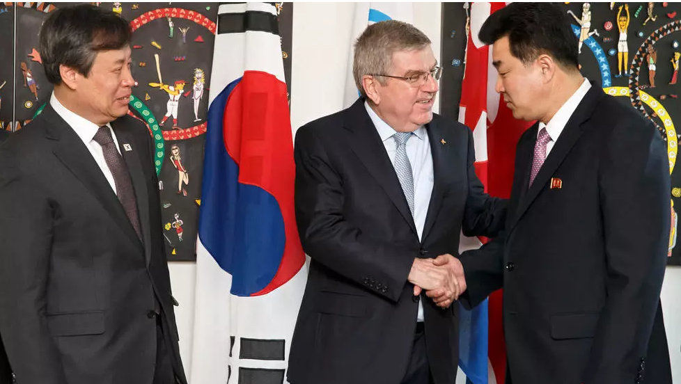 File photo of International Olympic Committee (IOC) president Thomas Bach shaking hands with North Korea's Olympic Committee President Kim Il Guk (R) next to South Korean Sports Minister Do Jong-hwan (L) at IOC headquarters in