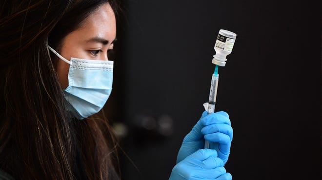 A COVID-19 vaccine is prepared for administration in Los Angeles on Jan. 7. FREDERIC J. BROWN/AFP Via Getty Images