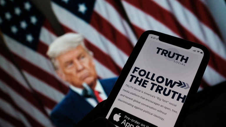 A person checks the App Store for ‘Truth Social’, with a photo of former US President Donald Trump in the background, in Los Angeles, October 20, 2021 © AFP / Chris Delmas/AFP