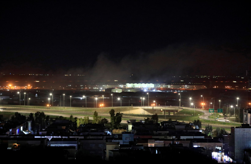 Smoke rises over the Erbil, after reports of mortar shells landing near Erbil airport, Iraq February 15, 2021 (Illustrative). (photo credit: THAIER AL-SUDANI/REUTERS)