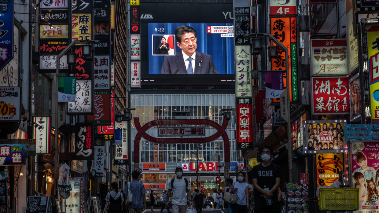 People pass by as Japan's Prime Minister, Shinzo Abe, is displayed on a giant television screen during a press conference in which he announced his resignation on August 28, 2020 in Tokyo, Japan ©  Getty Images / Carl Court
