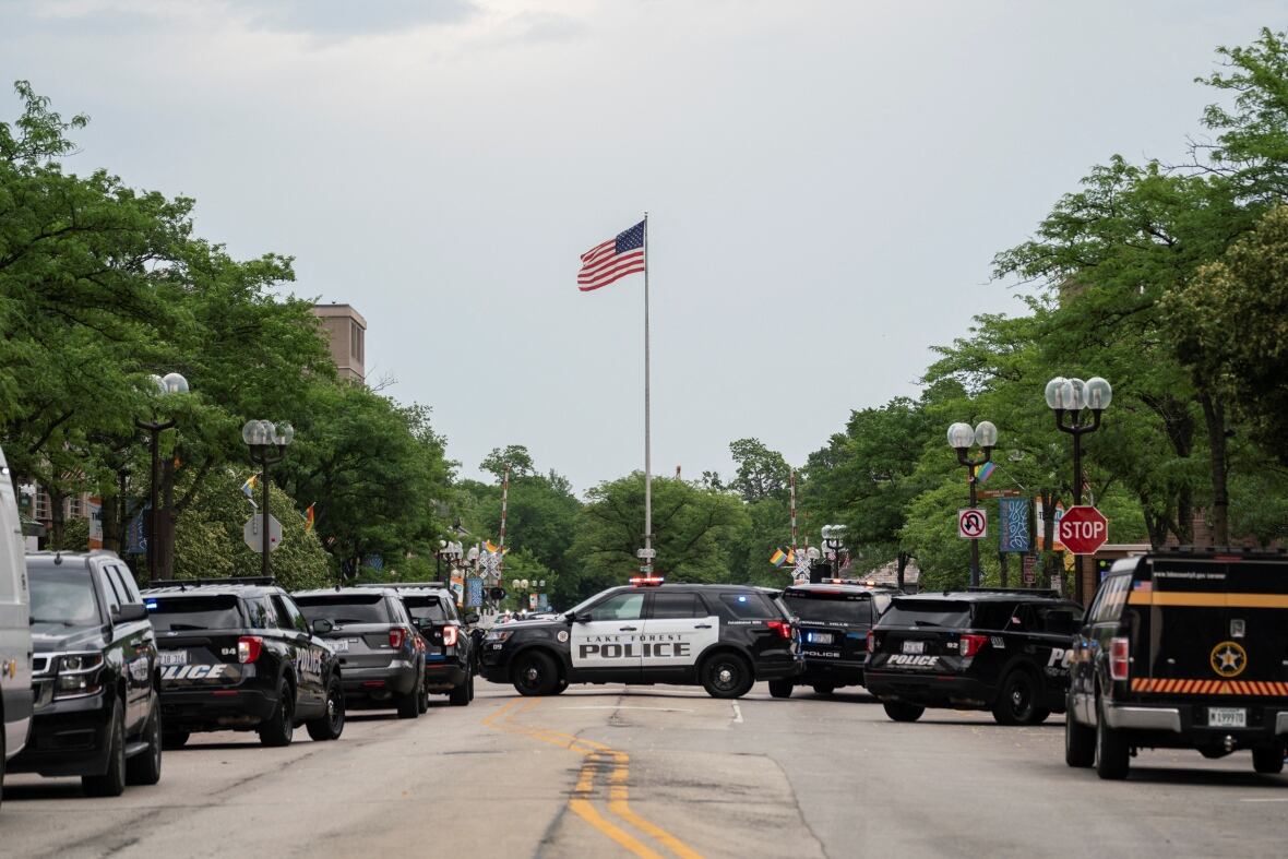 Police are seen along the parade route in Highland Park on Monday. (Max Herman/Reuters)
