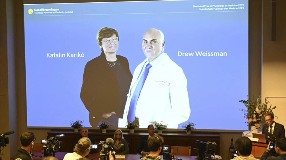 Thomas Perlmann, secretary of the Nobel Assembly, right, announces the winner of the 2023 Nobel Prize in Physiology or Medicine to Katalin Kariko and Drew Weissman, at the Karolinska Institute in Stockholm, on October 2, 2023. © Jessica Gow, AP