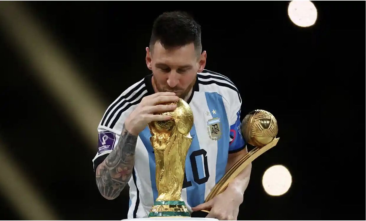 Lionel Messi kisses the World Cup trophy after receiving the golden ball award at the final in 2022. Photograph: Kai Pfaffenbach/Reuters