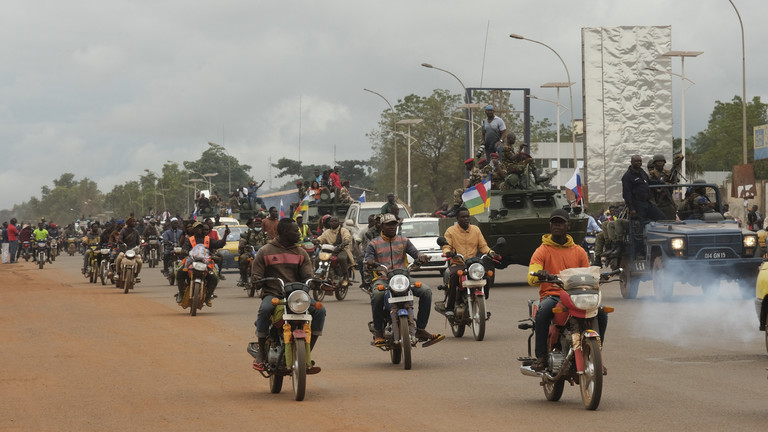 FILE PHOTO: Motorcycle taxi operators ride next to military vehicles that escorts the convoy of Russian armoured personnel carriers (APC) delivered to the Central African Republic army in Bangui, Central African Republic. © Camille Laffont / AFP