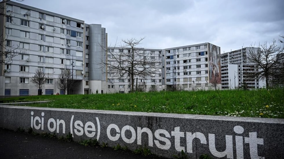 The Francs-Moisins estate near the Stade de France, just outside Paris, where a sign says "Here we build (ourselves)". © Julien de Rosa, AFP