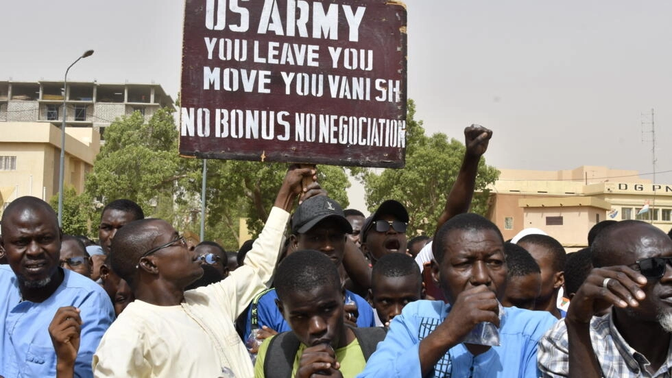 Protesters react as a man holds up a sign demanding that soldiers from the United States Army leave Niger without negotiation during a demonstration in Niamey, on April 13, 2024. © AFP