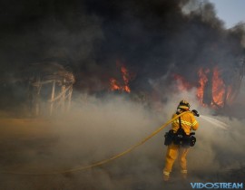 A firefighter battles a wildfire at Faria State Beach in Ventura, Calif., on Dec. 7, 2017. The wind-swept blazes have forced tens of thousands of evacuations and destroyed dozens of homes.