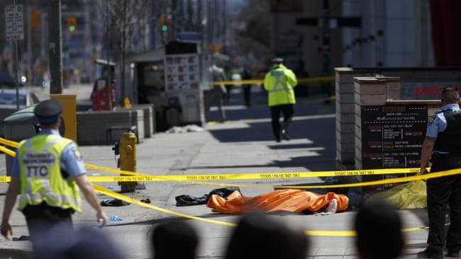 A tarp lays on top of a body on Yonge Street after a van ploughed into pedestrians in Toronto. Picture: AFPSource:AFP