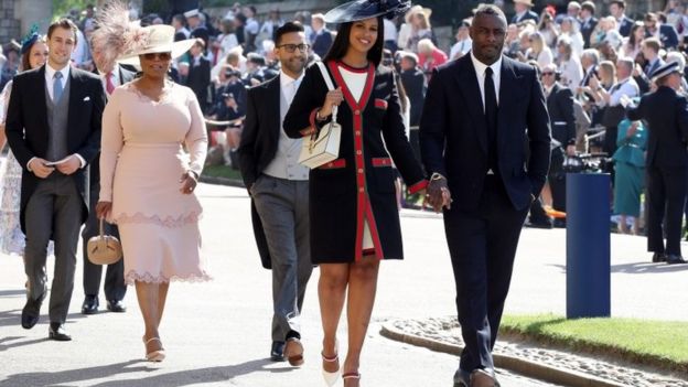 PA / US TV star Oprah Winfrey, wearing pink, and British actor Idris Elba arrive at the chapel