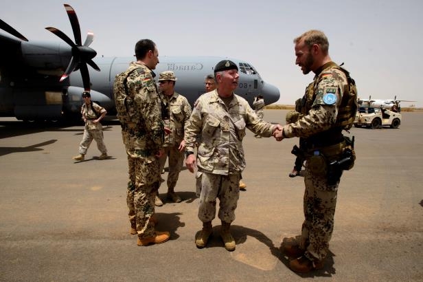 Chief of the Defence Staff General Jonathan Vance shakes hands with a German soldier as he