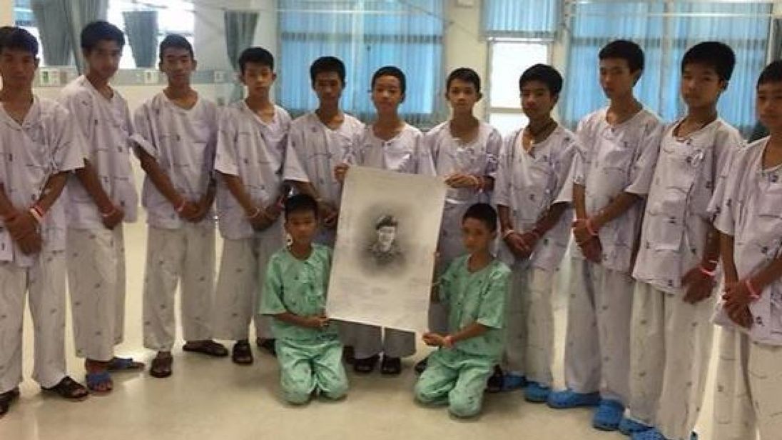 The boys with a picture of Saman Kunan, who died during rescue mission