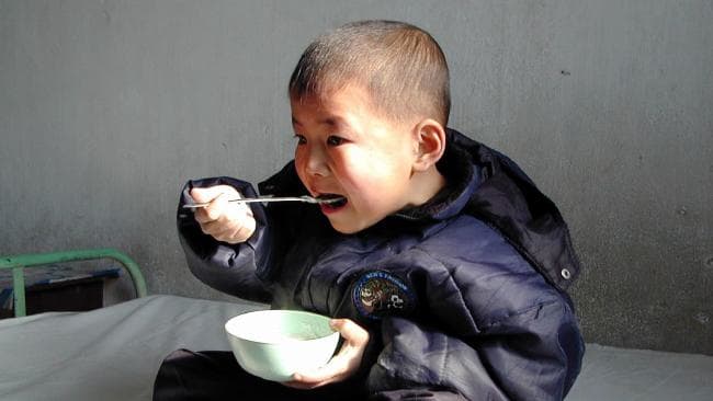 A malnourished North Korean boy eats vitamin and mineral-enriched food supplied by the United Nations World Food Program in 2004. Picture: APSource:AP