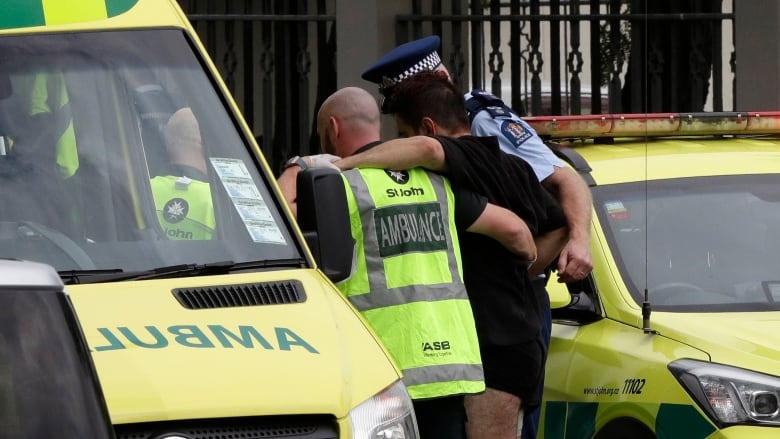 Police and ambulance staff help a wounded man from outside one of two Christchurch mosques attacked Friday in what the prime minister is calling 'one of New Zealand's darkest days.' (Mark Baker/Associated Press)