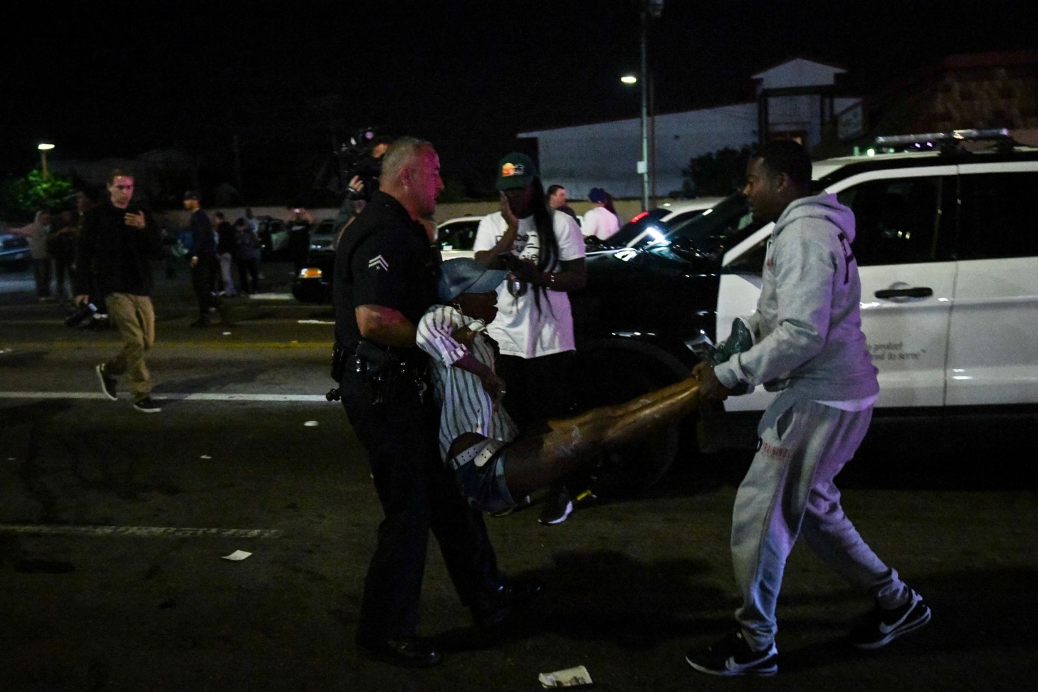 An injured woman is carried to an ambulance after multiple people were stabbed on April 1, 2019 in Los Angeles outside of Nipsey Hussle's clothing store. Harrison Hill, USA TODAY