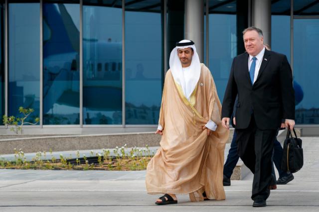 As his plane is reflected in the glass building behind them, Secretary of State Mike Pompeo, right, walks with Abu Dhabi Assistant Foreign Ministry Undersecretary for Protocol Affairs Shihad Al Faheem, as they say goodbye on the secretary's departure