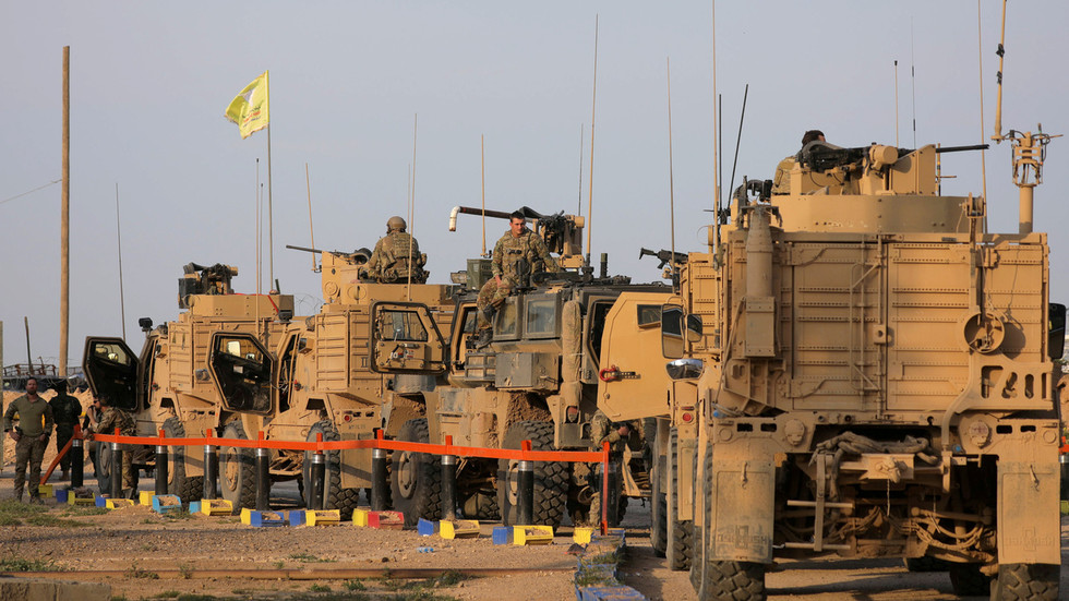 FILE PHOTO: American soldiers stand near military trucks, at al-Omar oil field in Deir Al Zor © Reuters / Rodi Said
