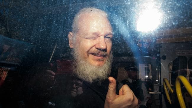 Julian Assange gestures to the media from a police vehicle on his arrival at court in April. Picture: Jack Taylor/Getty ImagesSource:Getty Images