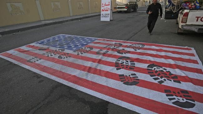 A mock US flag is laid on the ground for cars to drive on in the Iraqi capital of Baghdad on January 3 following the air strike. Picture: AHMAD AL-RUBAYE / AFP.Source:AFP