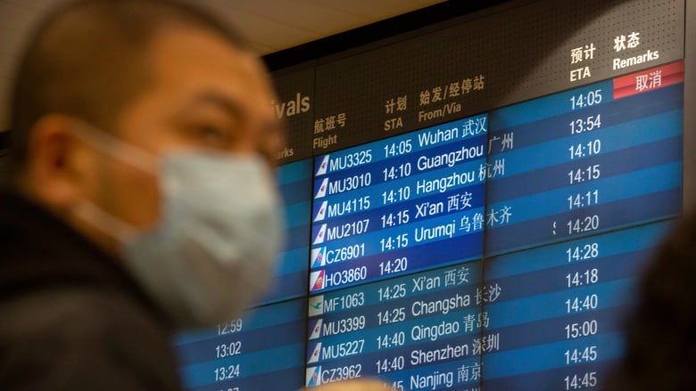 A display board shows a cancelled flight arrival from Wuhan at Beijing Capital International Airport in Beijing on Thursday. (Mark Schiefelbein/The Associated Press)