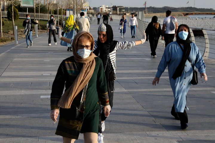 ASSOCIATED PRESS People wearing face masks exercise on the shore of an artificial lake, in Western Tehran, Iran, Sunday, March 15, 2020. (AP Photo/Vahid Salemi)