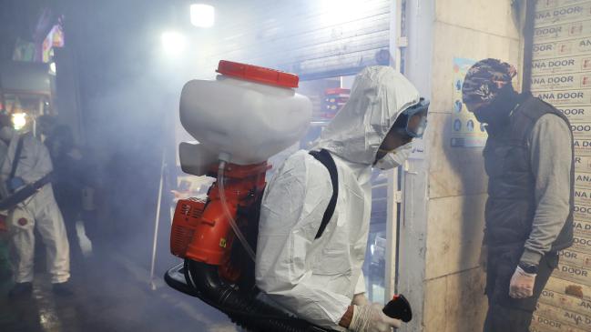 Firefighters disinfect a traditional shopping centre in northern Tehran. Picture: AP/Ebrahim NorooziSource:AP